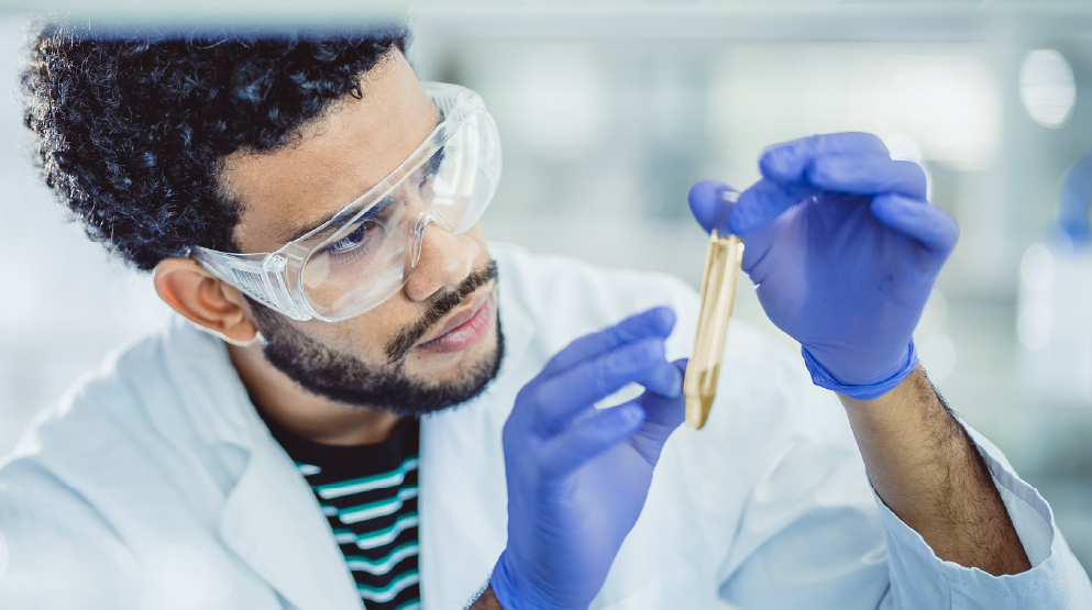 Technologue de laboratoire tenant un échantillon pour illustrer l'approche et la promesse Biron Génétique